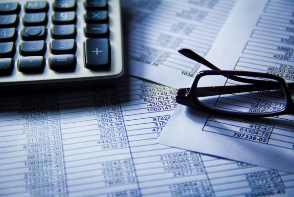 Business planning with calculator and glasses
