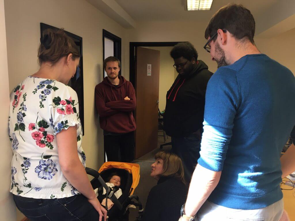 The CookiesHQ team gathered around a pram holding Nic and Nathalie's new baby, Amelie.